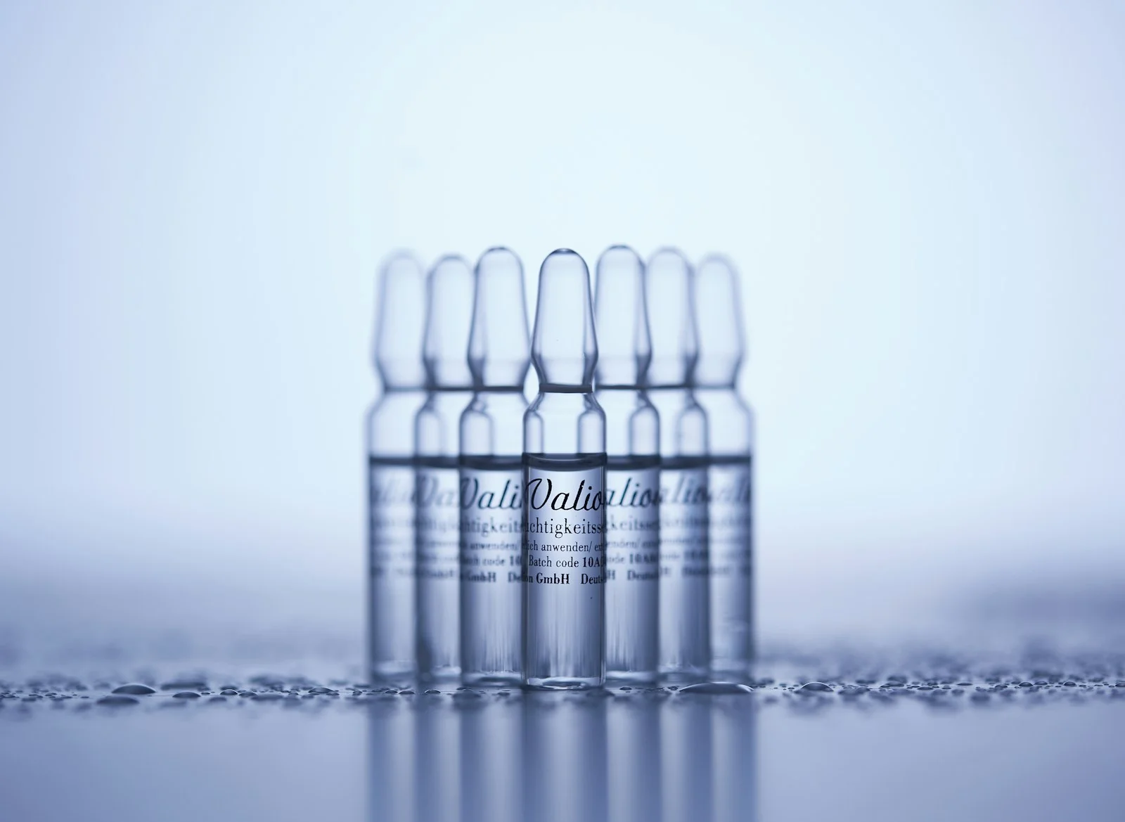 Row of clear glass ampoules on a laboratory surface