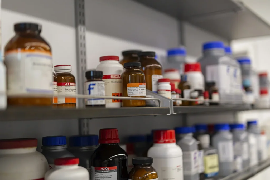 Shelves of labelled reagent bottles in a laboratory store room